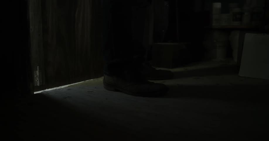 A person enters a dark shed