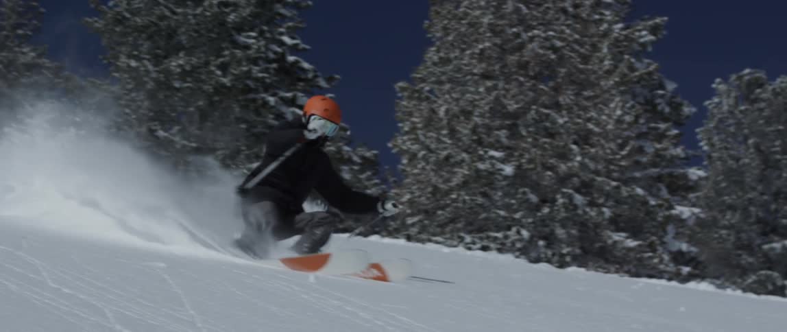 A man is sking down a hill