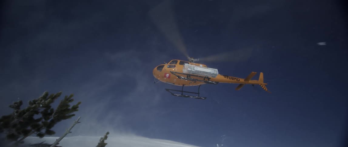 Orange helicopter lands in the snow