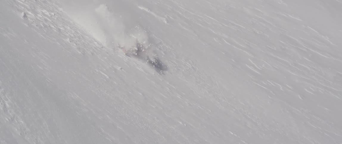 Person ski jumps over a steep hill and falls