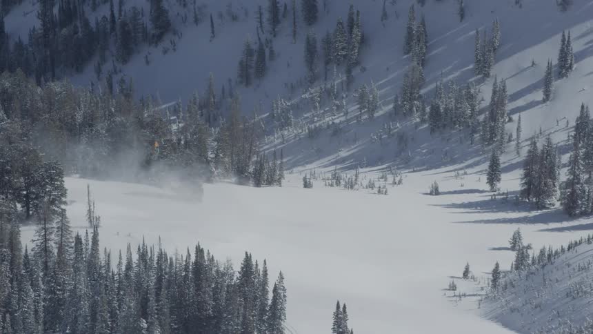 A helicopter flies in snowy mountains