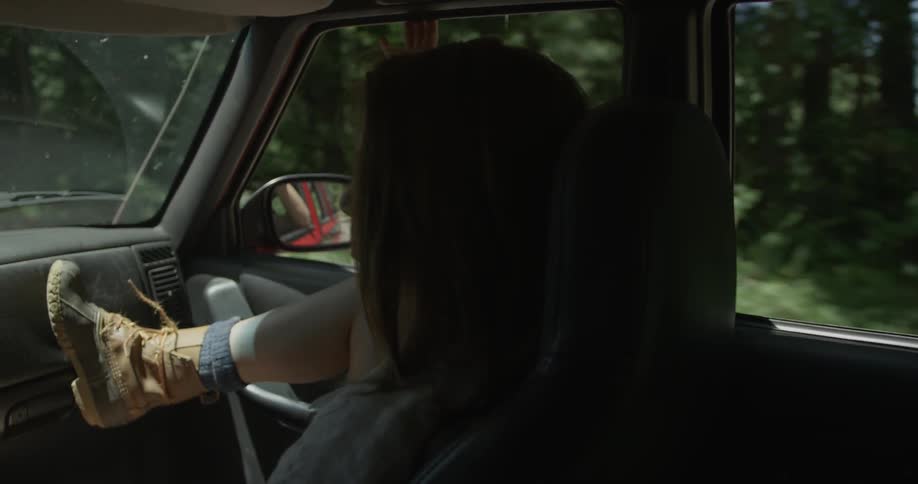 Woman rides in a vehicle through the forest