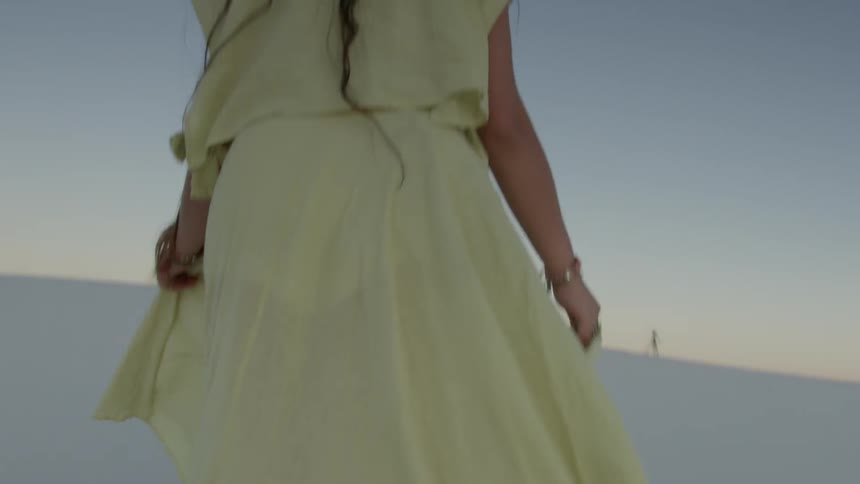 A woman turns around and hikes in the desert