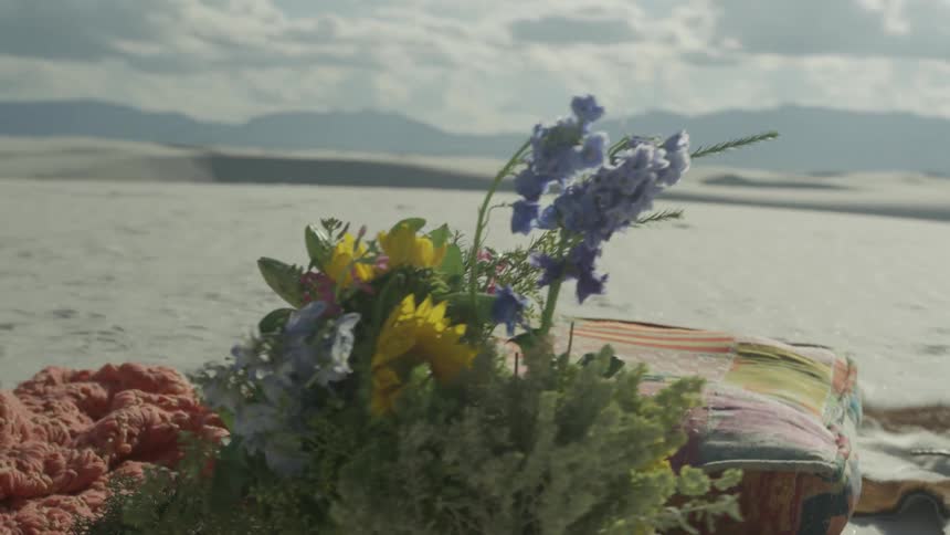 A bouquet of flowers sits on the beach