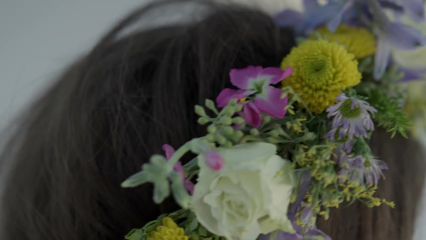 A woman wears a wreath of flowers on her head