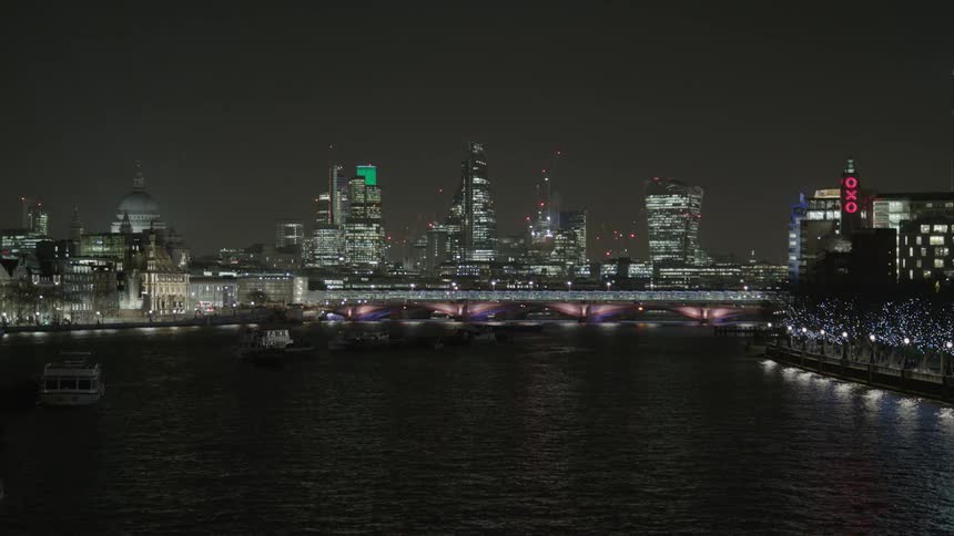 River water ripples in front of city skyscrapers at night