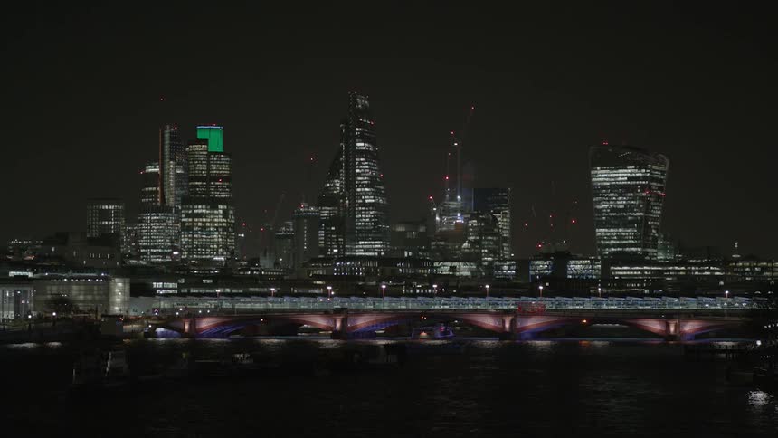 The row of tall buildings ahead are fully lit
