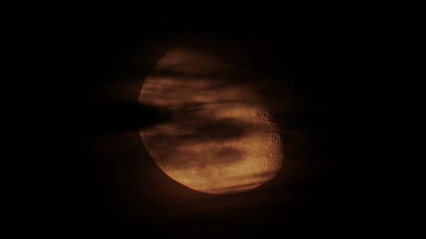 The full moon is being filmed through clouds