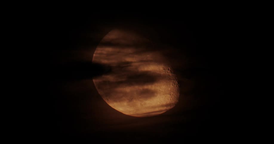 The full moon is being filmed through clouds