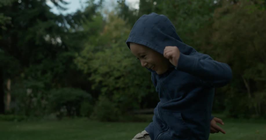 Smiling child jumps and plays in a yard