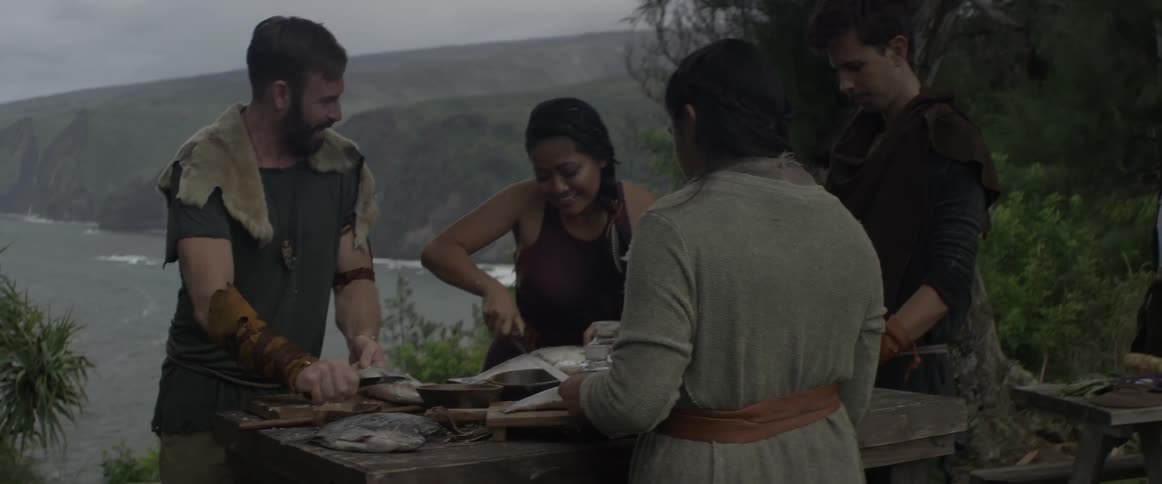 A group of being wearing viking clothes are cleaning fish
