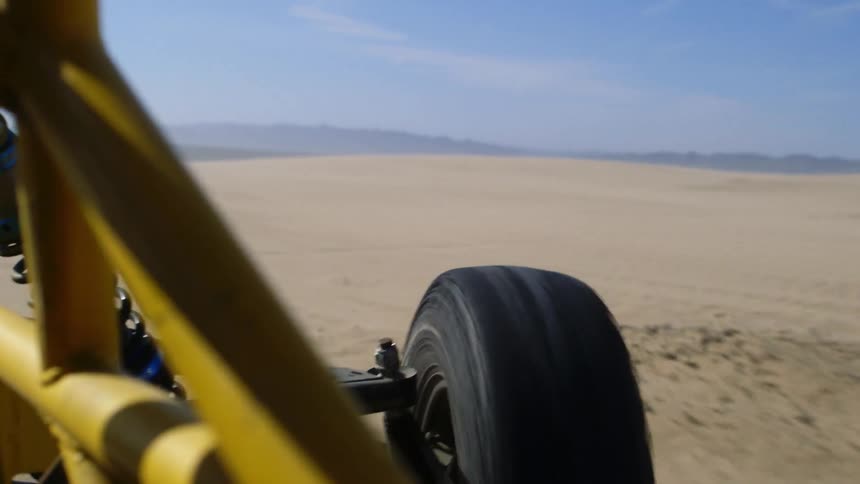 An off-road racing vehicle drives across the desert