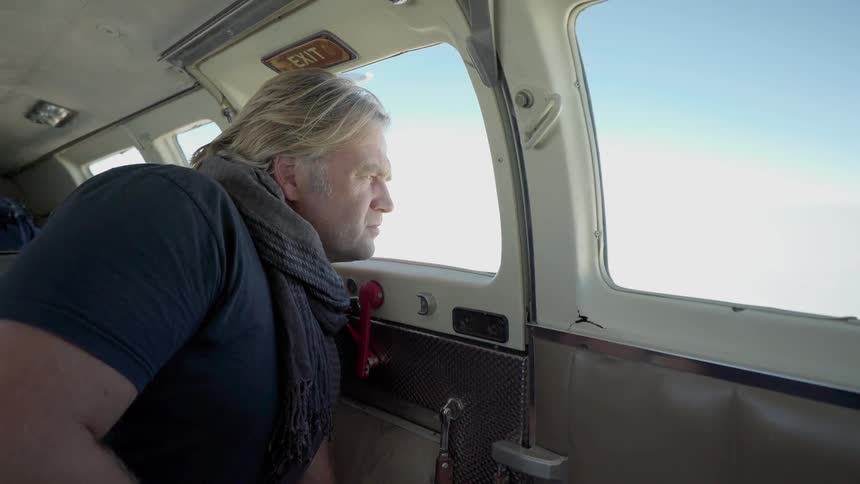 A man looks out of a plane window