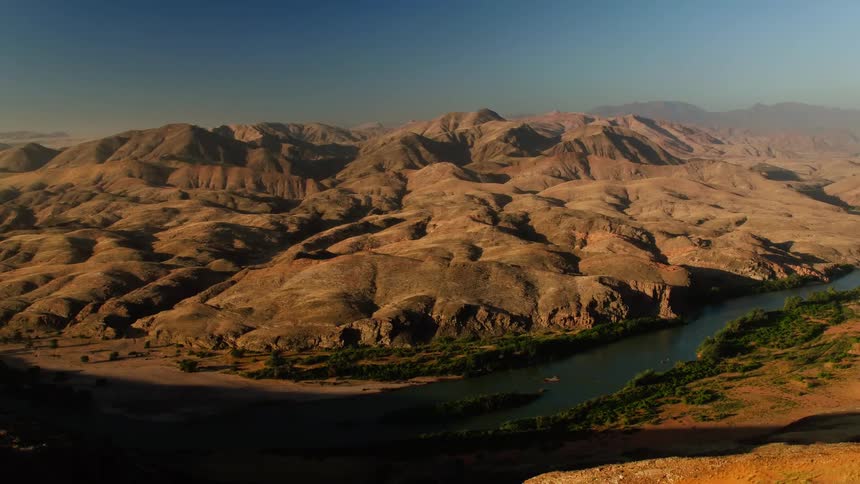 A river runs through the mountains on a sunny day