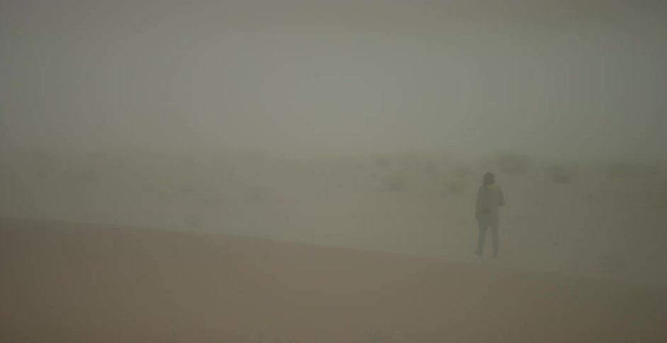Man walks through the dusty desert
