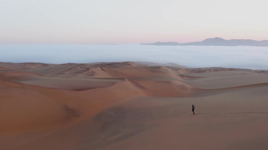 A person is walking through the desert by themselves