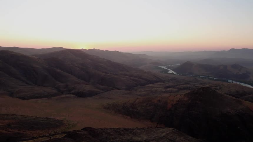 The mountain range has the sun setting behind