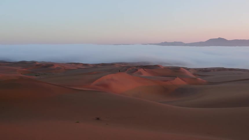 Sand dunes and clouds covering part of the desert