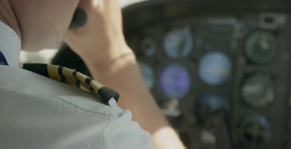 A pilot adjusts knobs preparing for flight