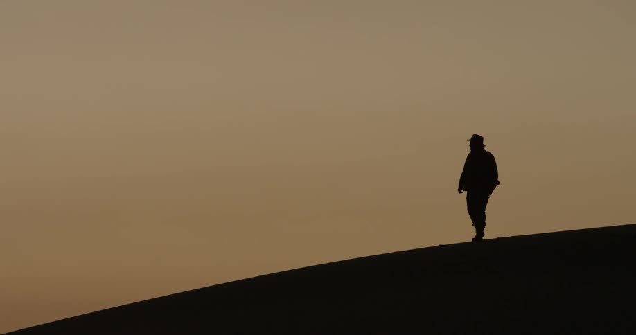Man walking on a hill in the desert
