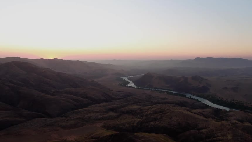 A valley with a river is being filmed from the air