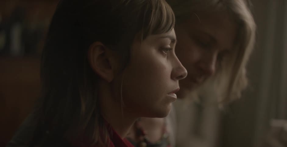 Sad looking woman is talked to by another woman