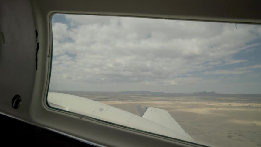 View looking out of an airplane window as it takes off