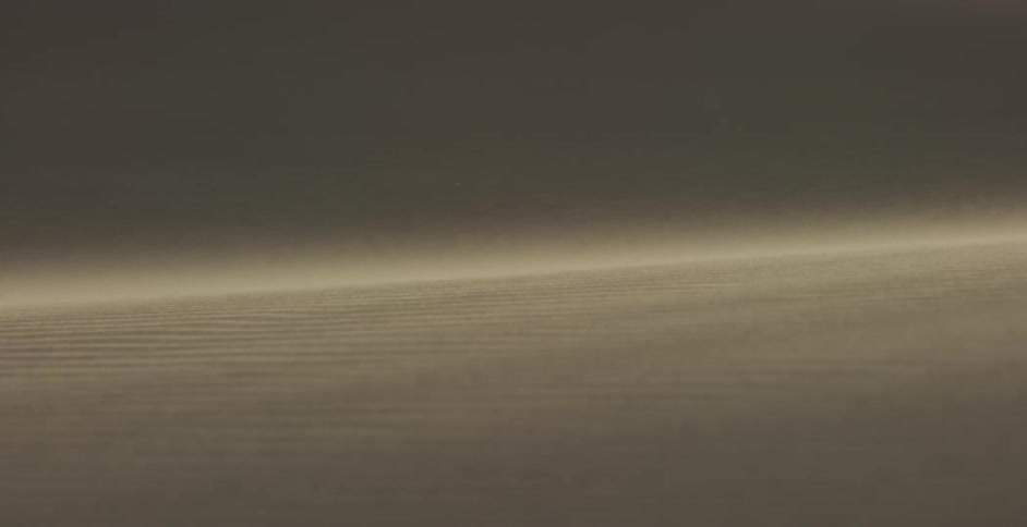 Wind is blowing the sand down a dune in the desert