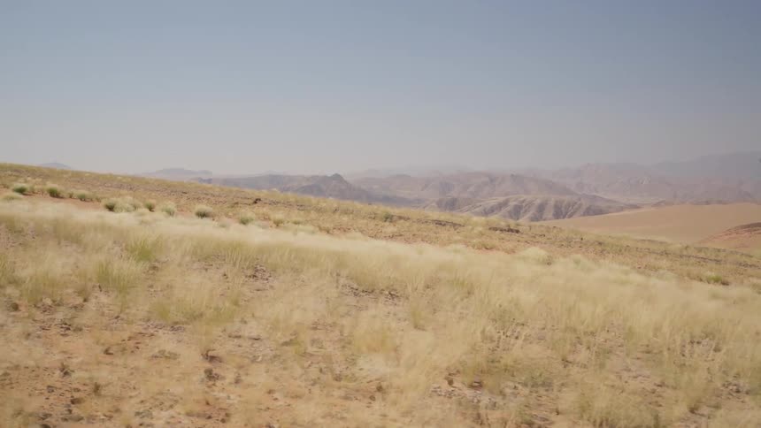 Desert plains overlooking a valley with hills beyond that