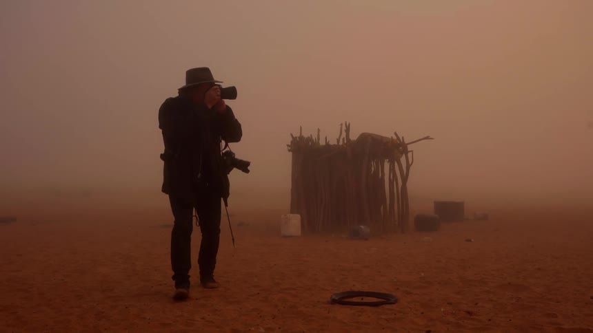 A photographer takes pictures on a foggy day