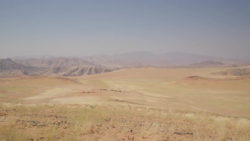 A man is standing in the desert looking over the horizon