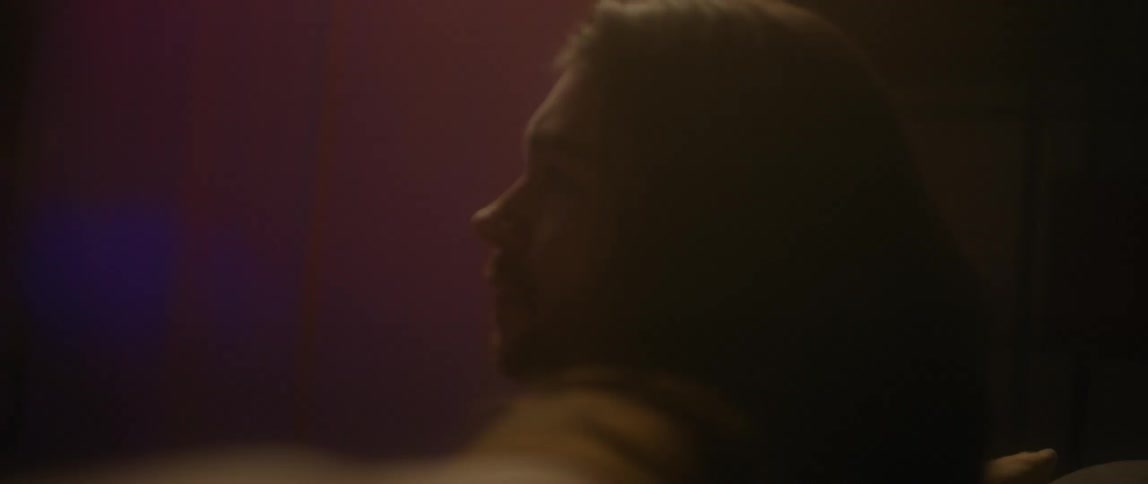 A man with long hair is sitting on a couch
