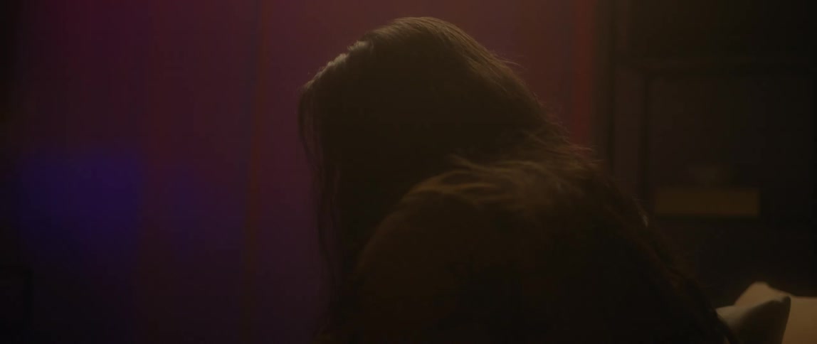 Bearded man with long hair sits in a room