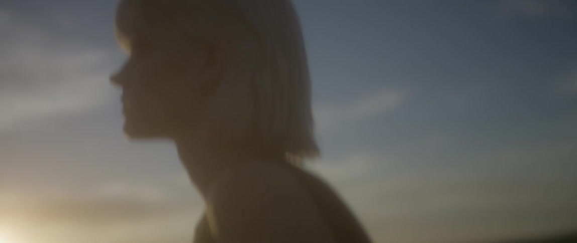 A woman walks outside at sunset