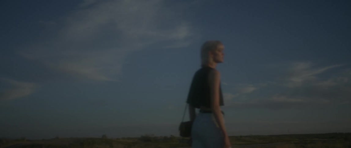 Woman walks outside at sunset