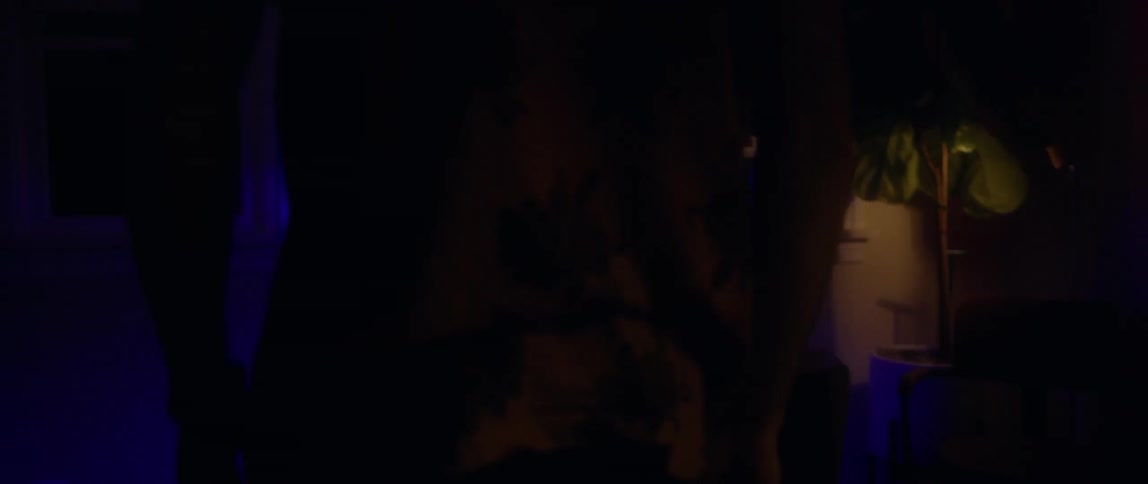 A man is standing in a foggy room next to a fish tank