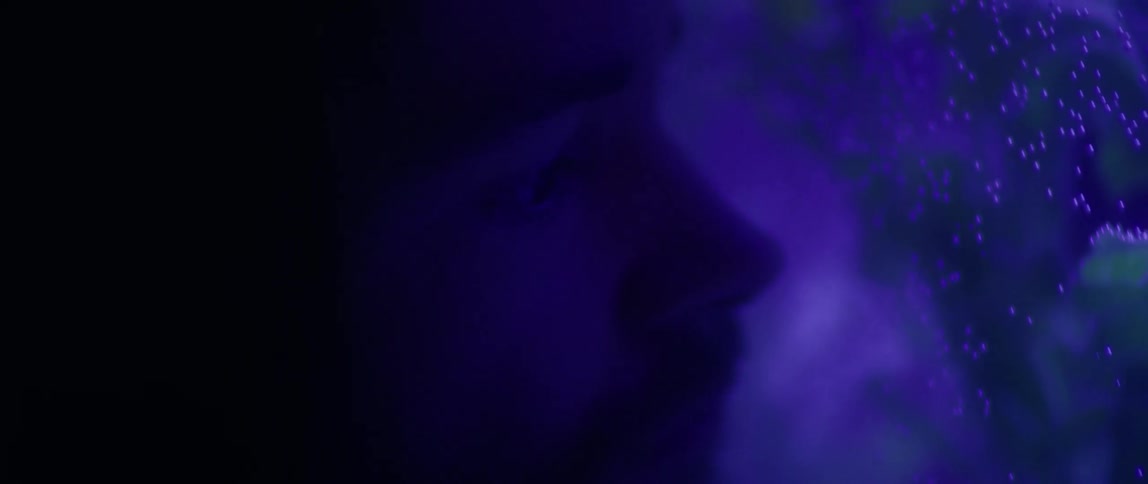 A person is near a fish tank reflecting blue light