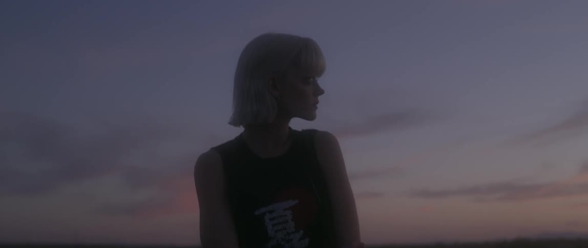 A woman looks to the side at dawn
