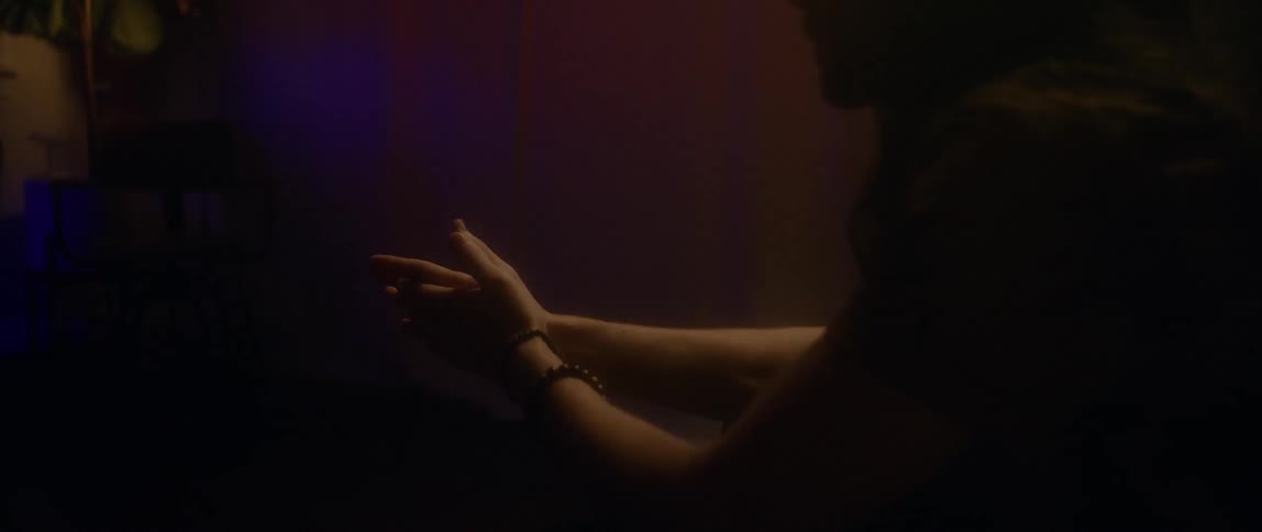 A woman sits down rubbing her hands and crying