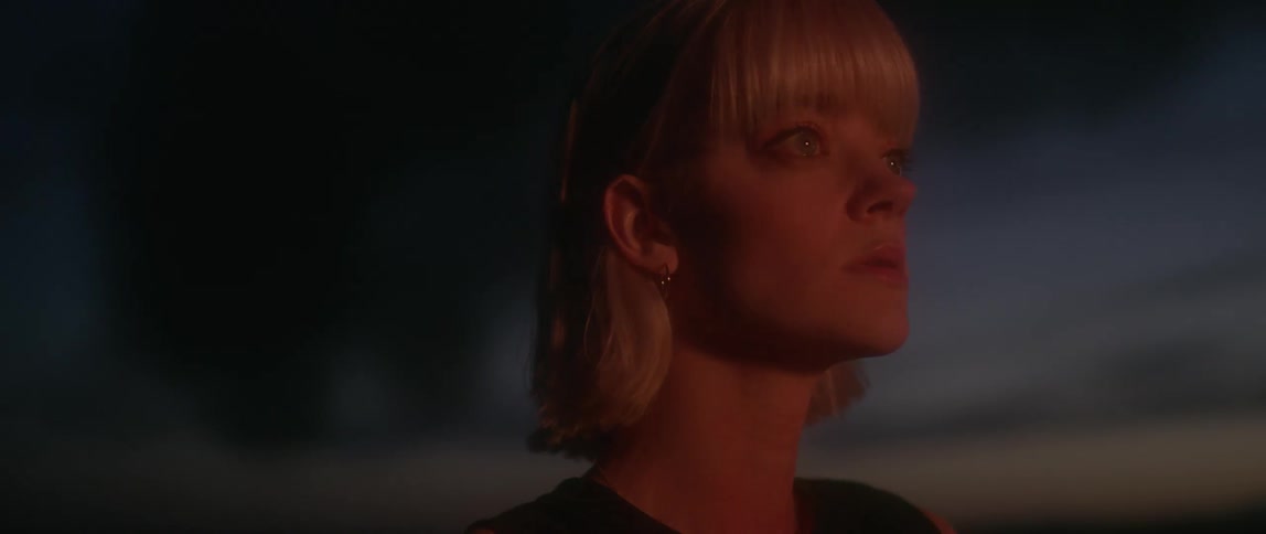 A woman is watching a car that's off screen burn
