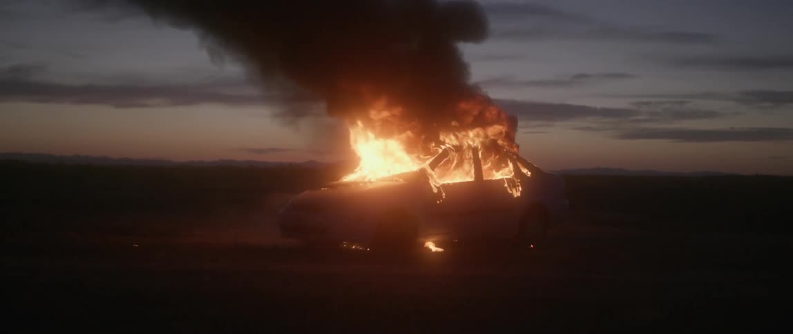 A car is on fire at dusk
