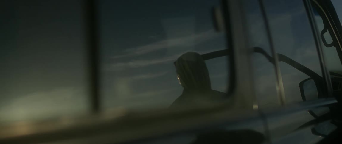 A man with a mask closes a car door