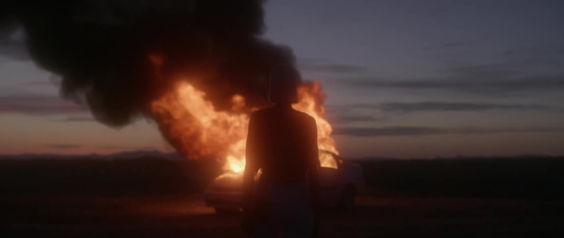 A woman is standing in front of a fire