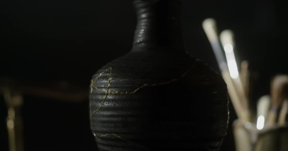An old clay vase is sitting on a desk