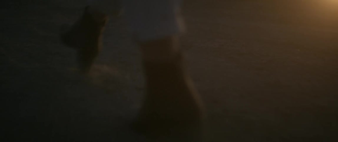 Woman walking outside in high heel boots as sun sets