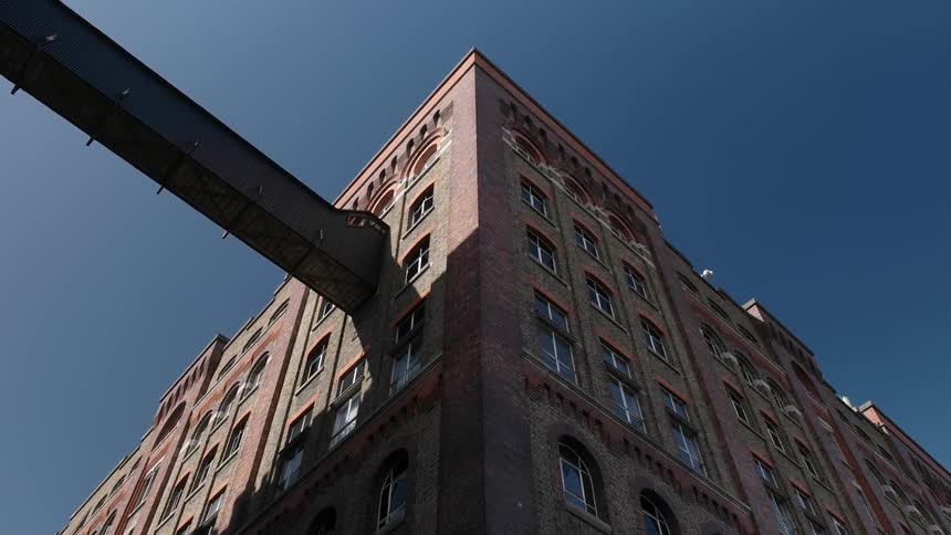 Tall building with many windows sits under a blue sky