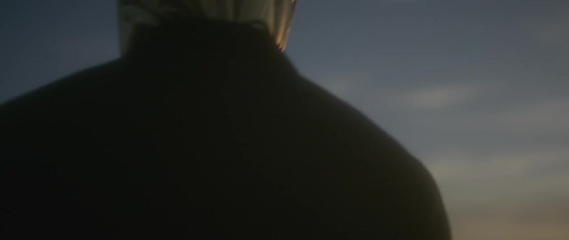 Person in dark clothing has his head covered