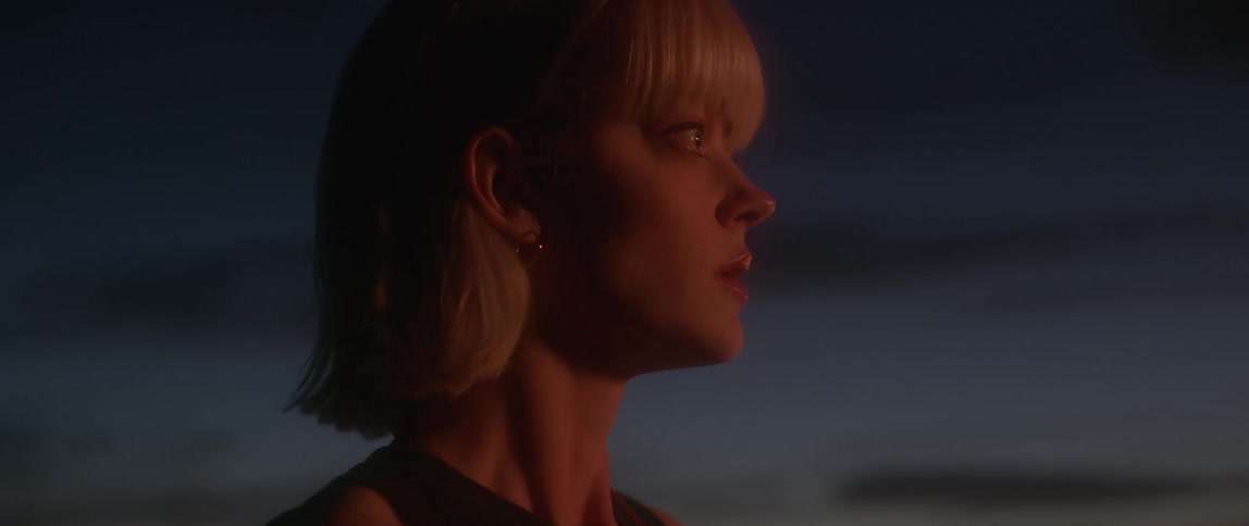 A woman is standing looking at something off screen