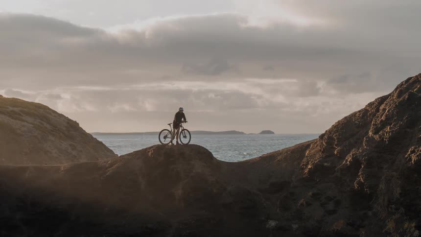 A man is on his bicycle on top of a mountain
