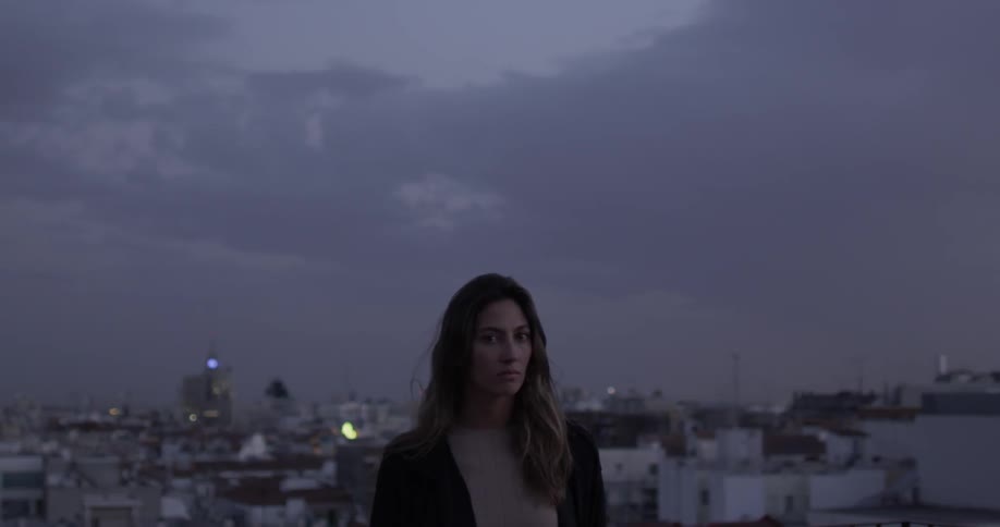 A woman is looking out over the town at sunset